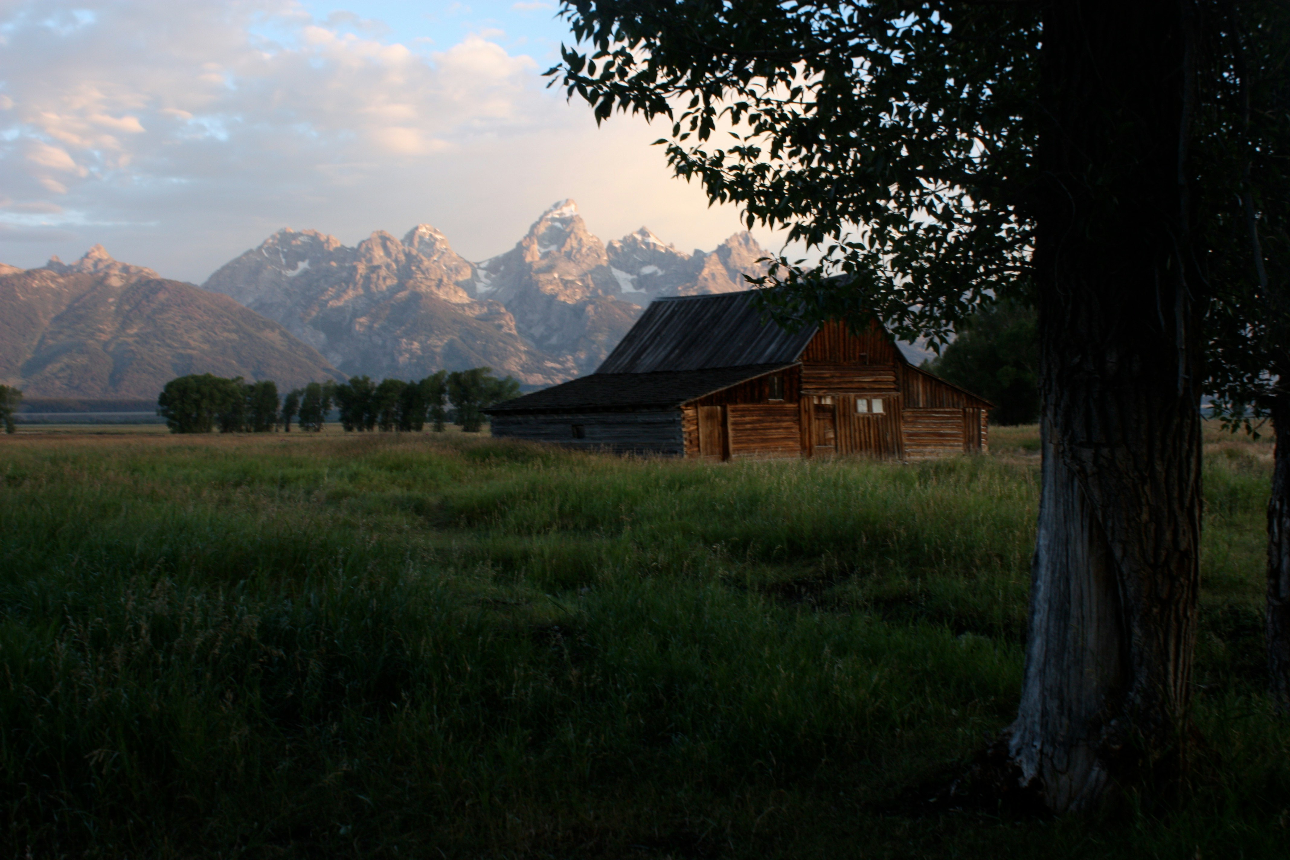 house on grass field near mountain